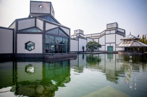 White and dark geometric architecture reflected in the water at Suzhou Museum