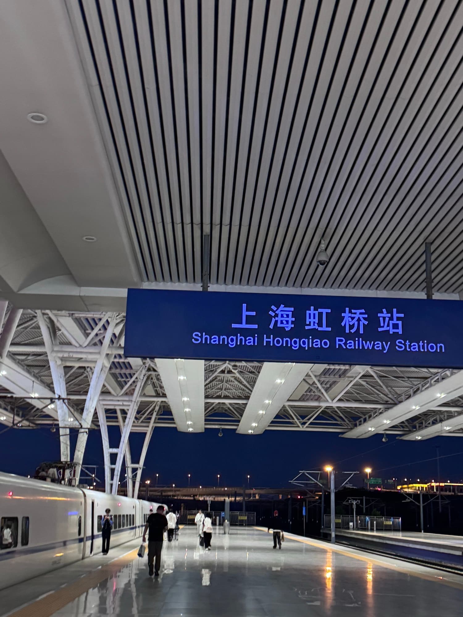 Platform sign reading Shanghai Hongqiao Railway Station in Chinese and English