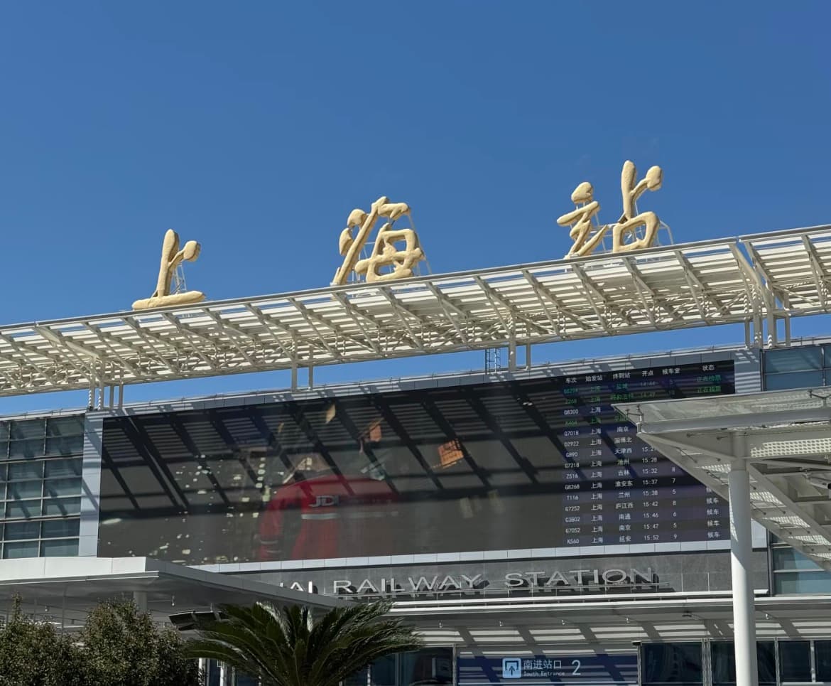 Exterior entrance of Shanghai Railway Station under a clear blue sky