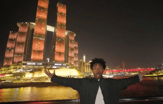 IShowSpeed posing in front of Chongqing’s illuminated riverfront skyline